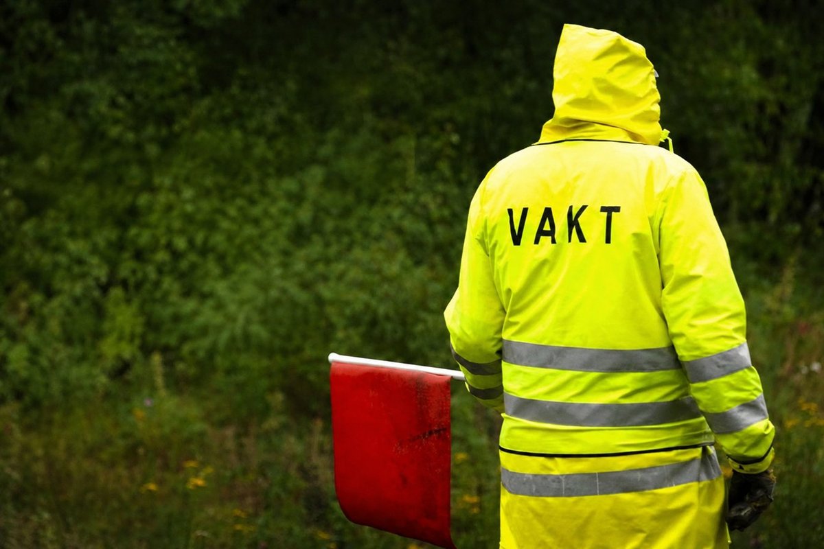Flaggvakt som dirigerar trafiken vid ett vägarbete i Örebro